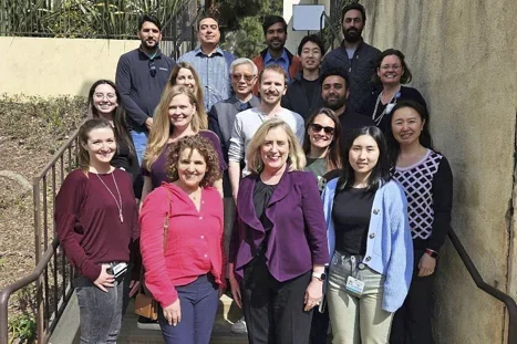Reed Lab members standing on steps smiling.